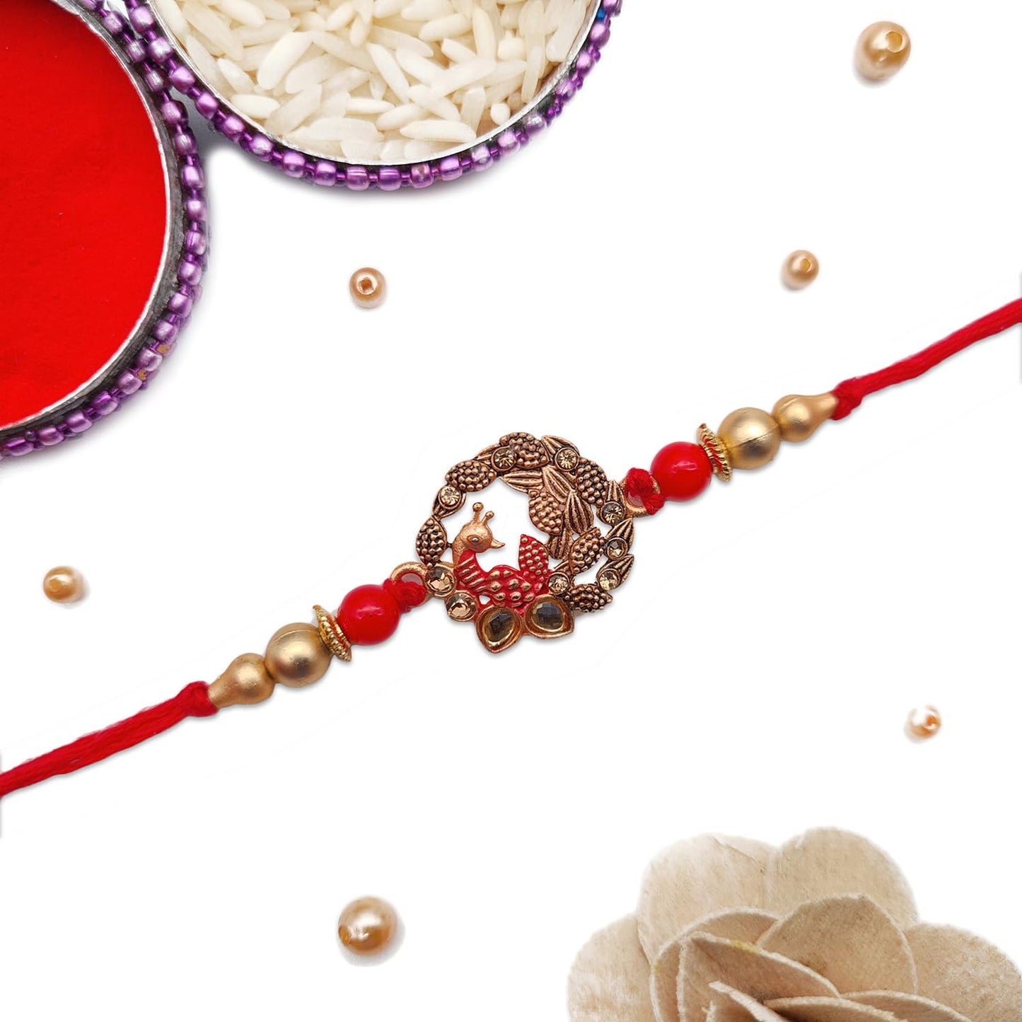 Rakhi made of red and gold thread, featuring a beautiful gold bead for a special occasion.