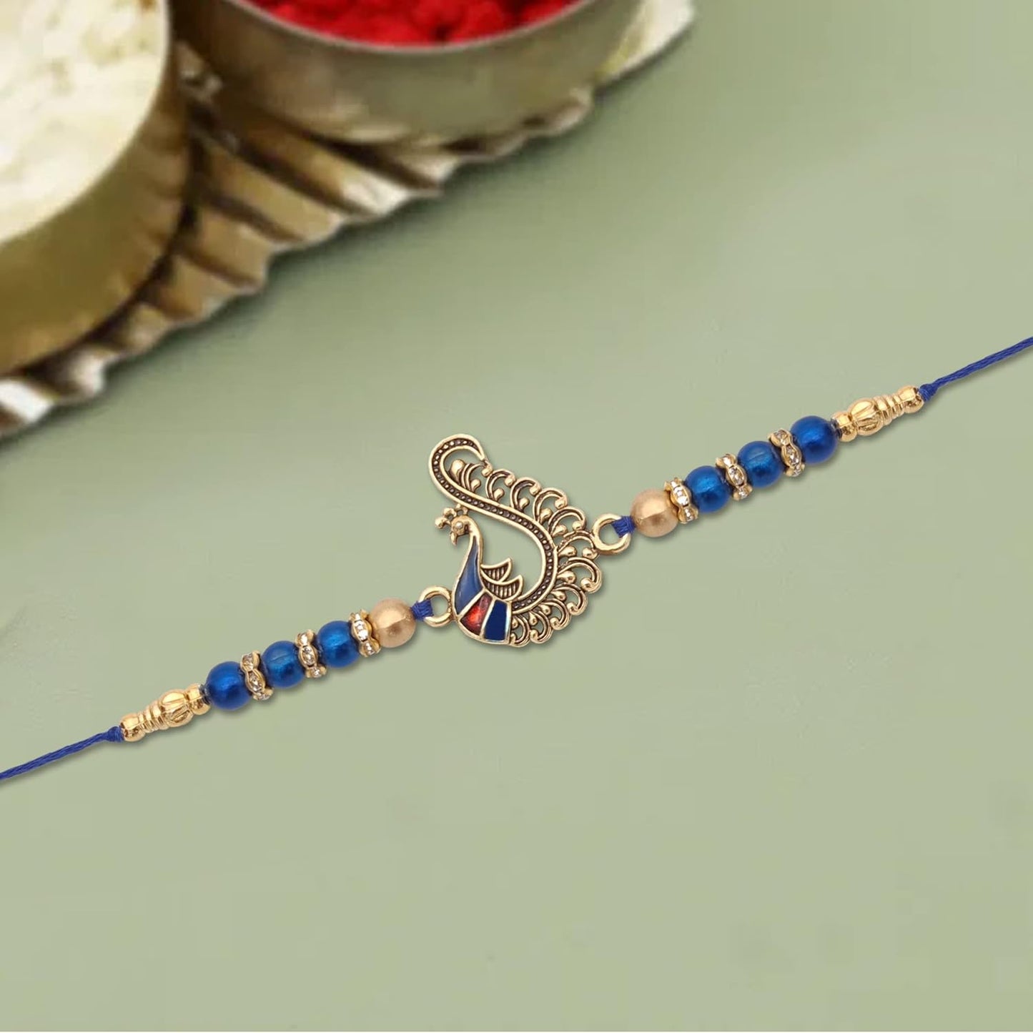  Elegant blue rakhi featuring a beautiful peacock design, ideal for Raksha Bandhan.