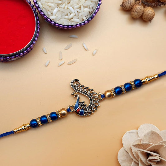 Blue rakhi with intricate peacock design, perfect for celebrating Raksha Bandhan.