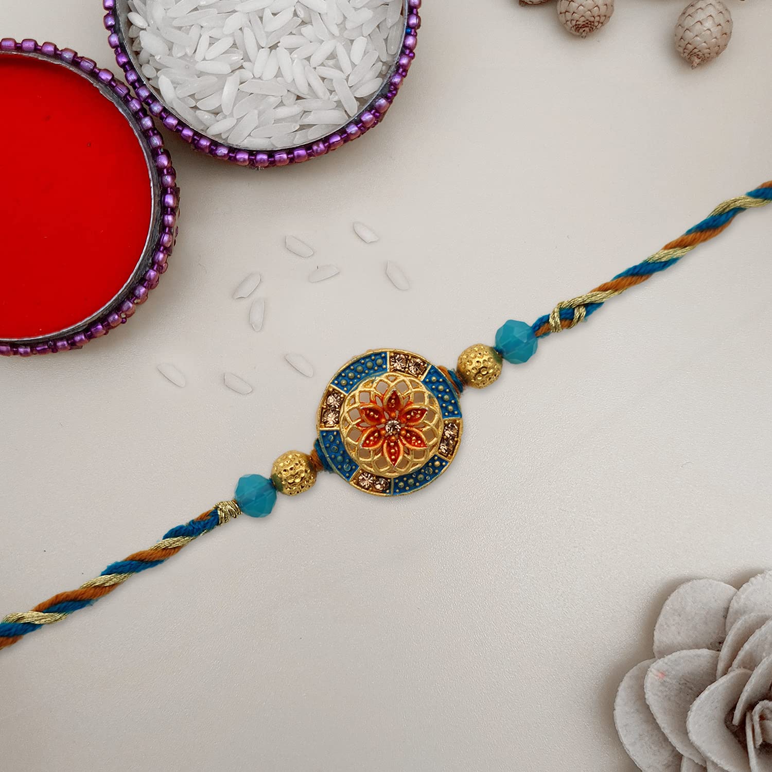 A flower-patterned gold and blue rakhi, a symbol of sibling love and protection.