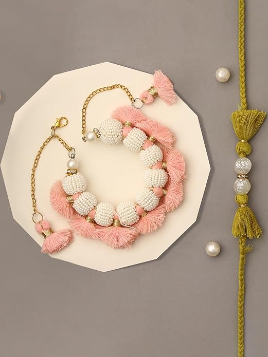 Pink and white tasseled Rakhi with pearls on a white background.