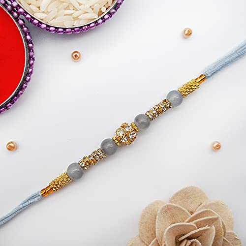 A rakhi with a gold and silver bead, symbolizing love and protection between siblings.