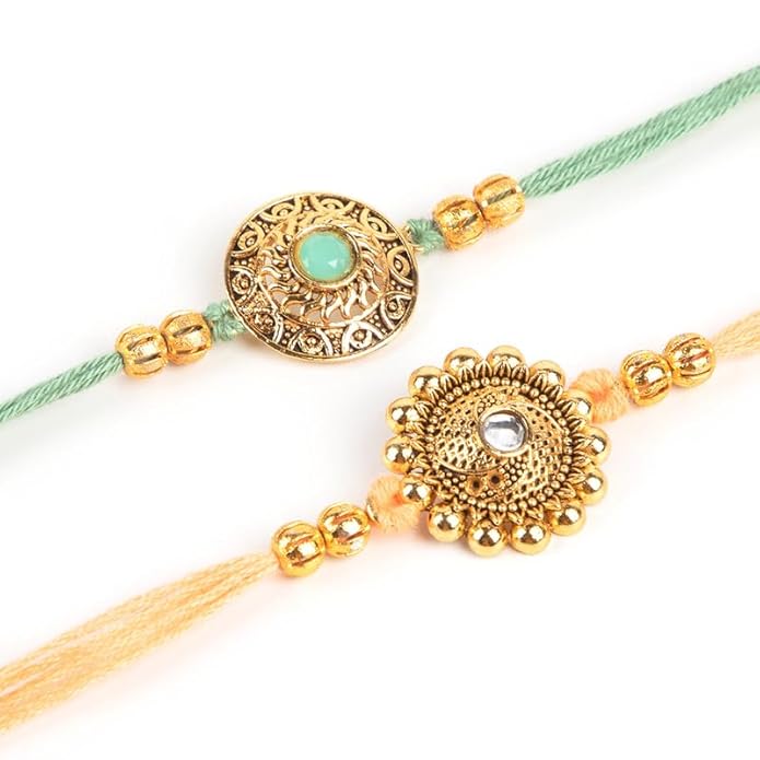 Two rakhi bracelets with elegant gold and green threads, embodying the tradition of sibling love and protection.