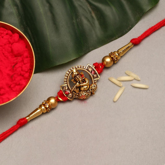  Traditional rakhi with red and gold threads, representing the bond between brothers and sisters.