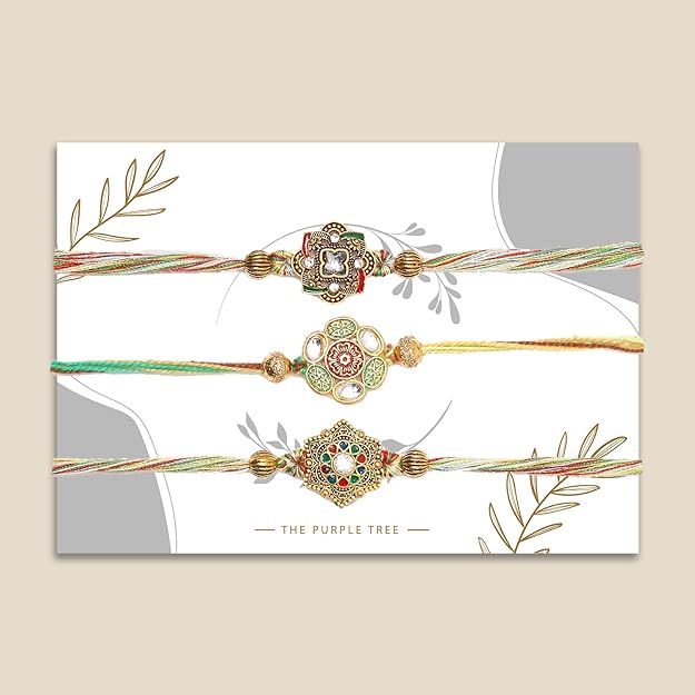 Trio of rakhi's in various hues, each with a flower.