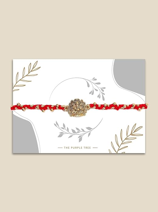 A festive red and gold Rakhi with a beautiful flower on top, symbolizing the joy of Raksha Bandhan.