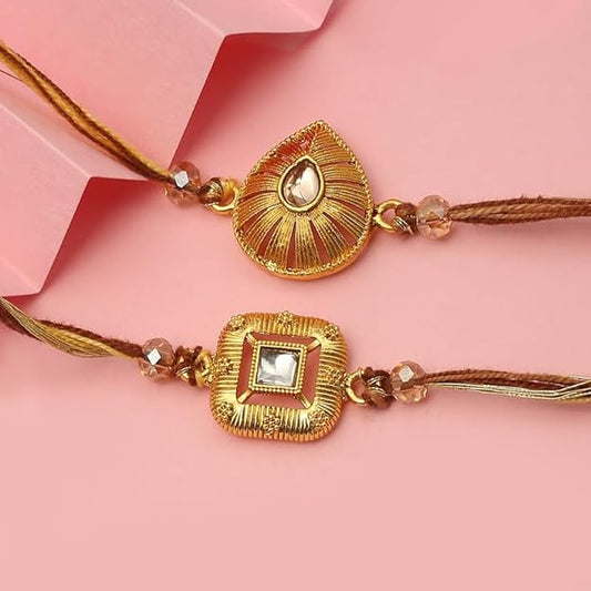 Two gold plated rakhi with heart and diamond charms.