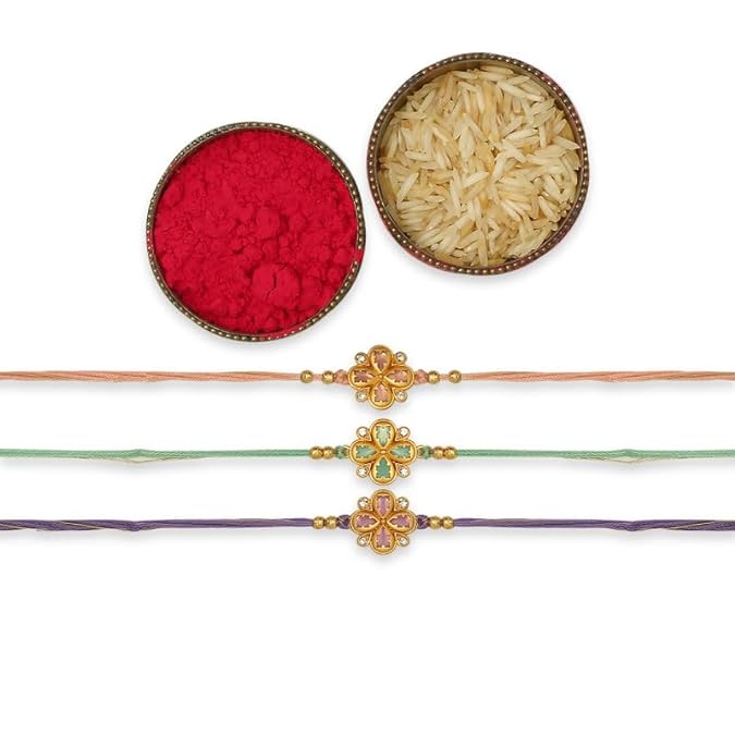 Three vibrant rakhi's with gold thread, accompanied by a bowl of rice and red powder.