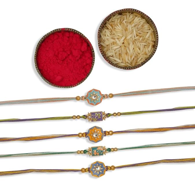 Four colorful rakhi with pearls and beads, symbolizing love and protection, accompanied by vermilion and a bowl of rice.