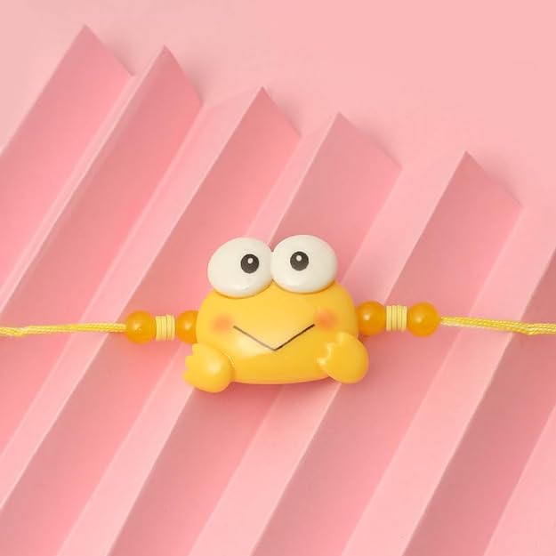 Yellow frog rakhi with yellow face on pink background.