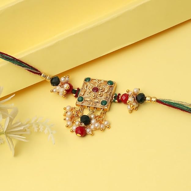  Gold plated rakhi with green, red, and white beads, symbolizing love and protection, perfect for Raksha Bandhan.