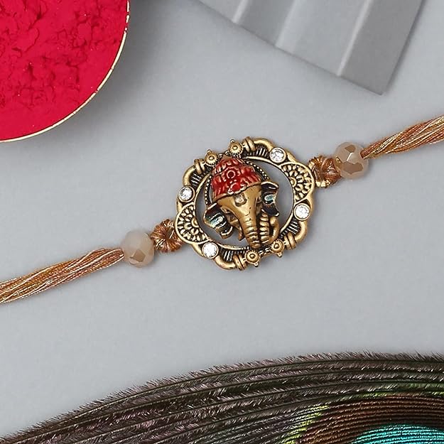 A gold and red rakhi with a red bead, symbolizing the bond of love and protection between siblings.