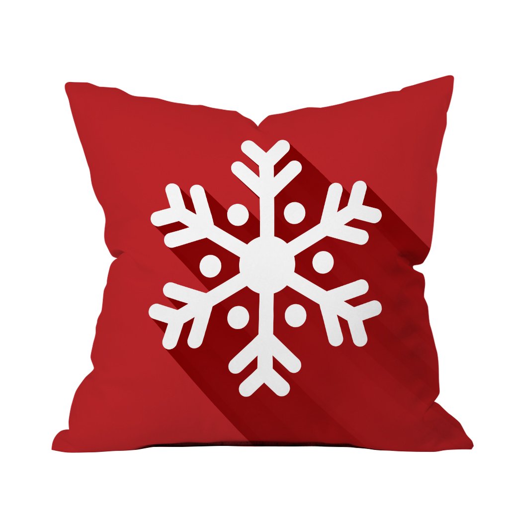 A red and white snowflake pillow rests against a clean white background, adding a festive touch to the decor.

