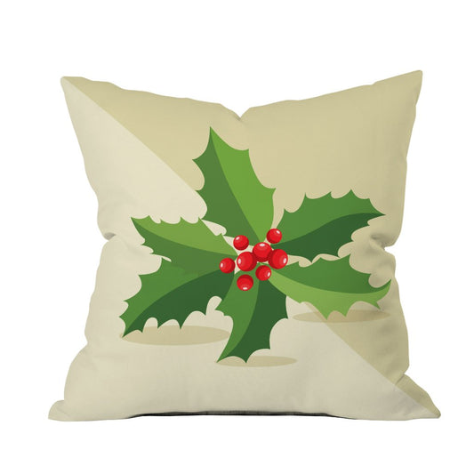 A decorative pillow featuring a holly leaf and red berries, perfect for festive home decor.

