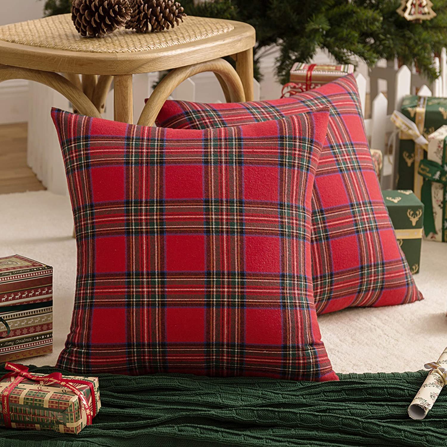 Two cozy red plaid pillows resting on a soft white rug, adding a pop of color to the serene space.