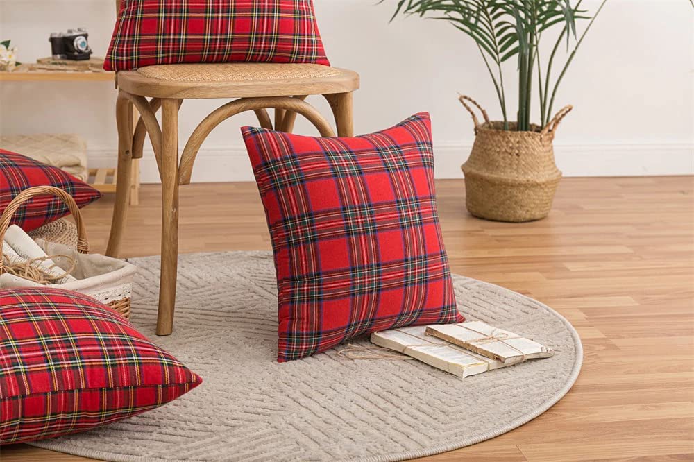 A pair of vibrant red plaid pillows placed on a clean white rug, creating a warm and inviting atmosphere.