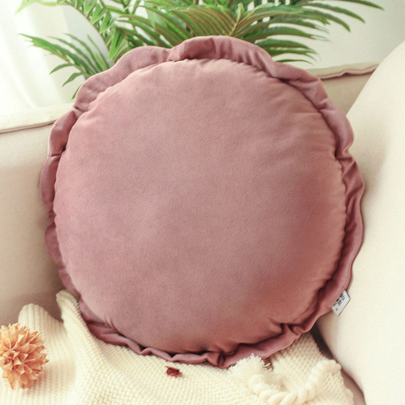 A round pillow adorned with red ruffles, adding a touch of elegance and charm to any space.