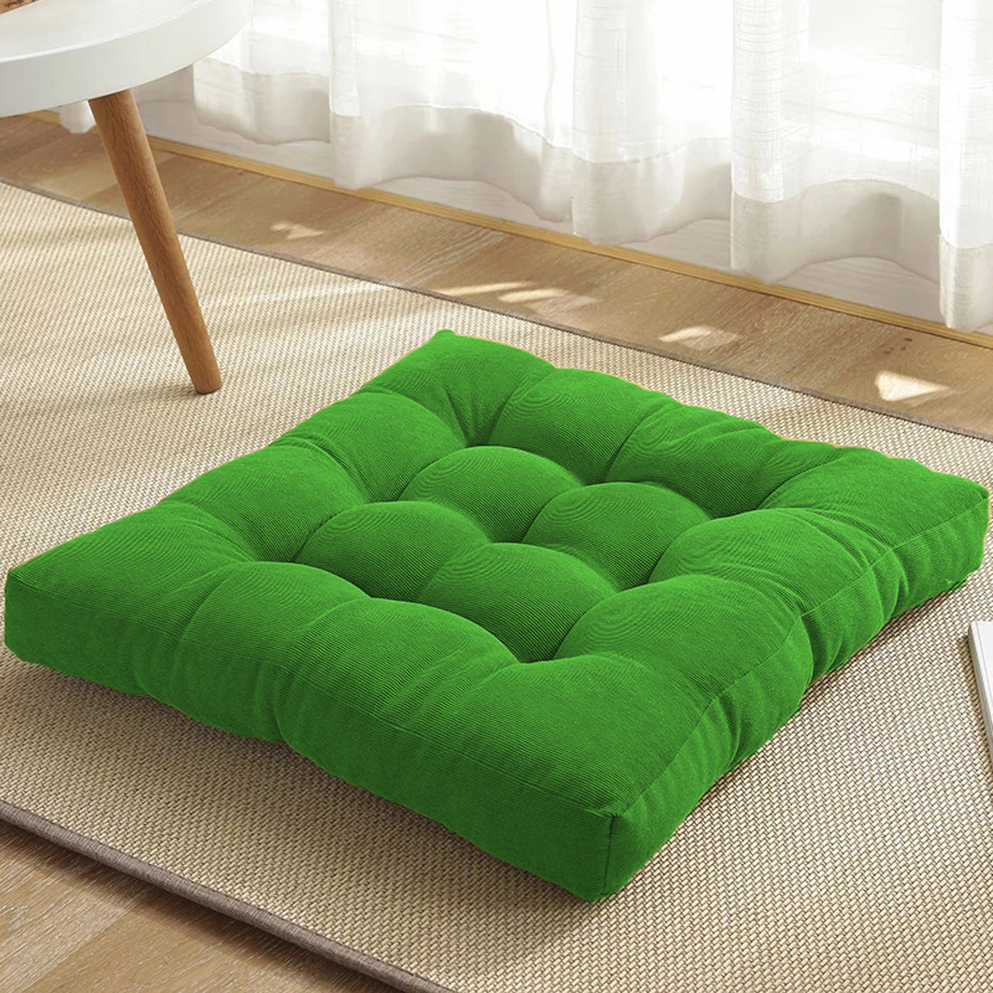 Square cushion in green color on floor