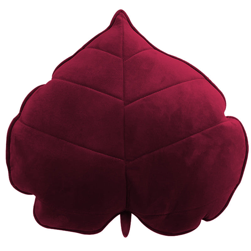 A cozy  leaf-shaped cushion on a clean white background, perfect for adding a touch of nature to your home decor.