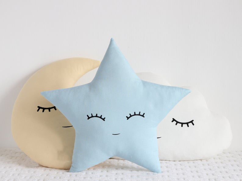 Decorative pillows with cloud, star, and moon motifs.