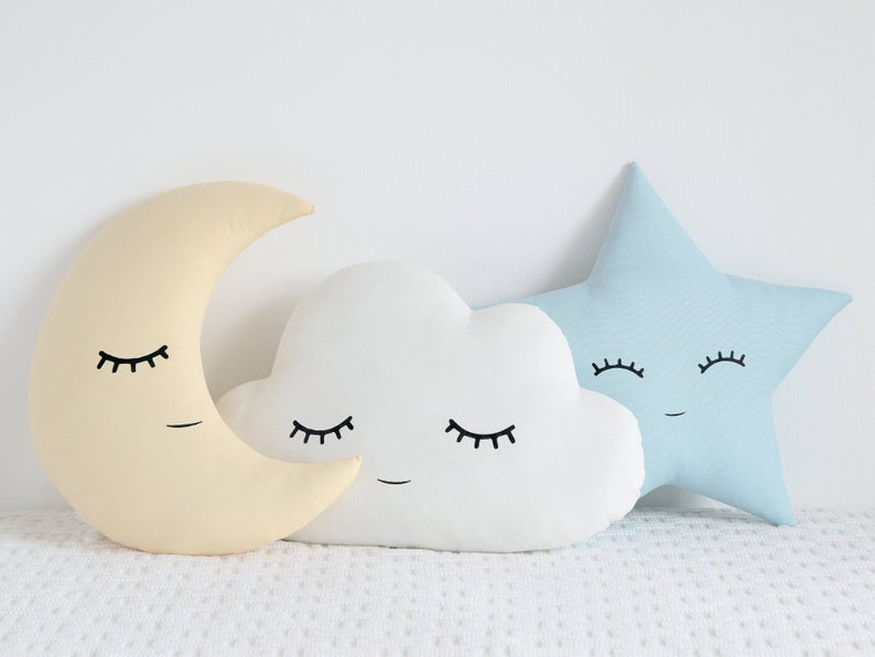 Three pillows featuring a cloud, star, and moon designs.