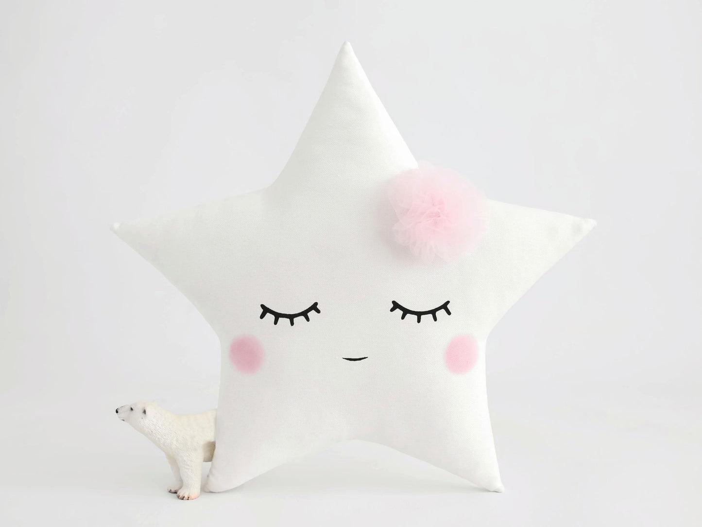 4. White pillows adorned with pink eyes and a star motif.