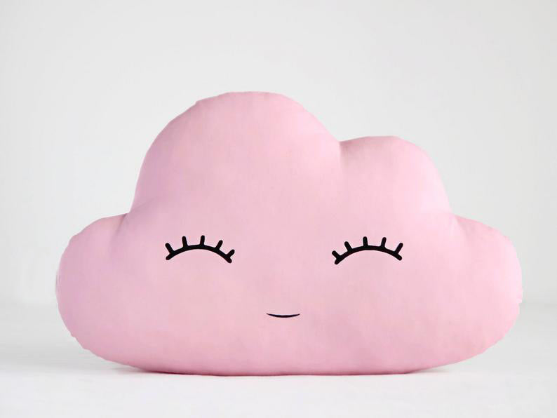 Whimsical pink cloud pillows with cute eyes and eyelashes, ideal for creating a cozy and inviting atmosphere.