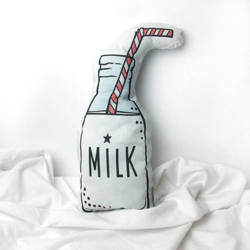 A pillow with a milk bottle and straw, perfect for a cozy bedtime snack.