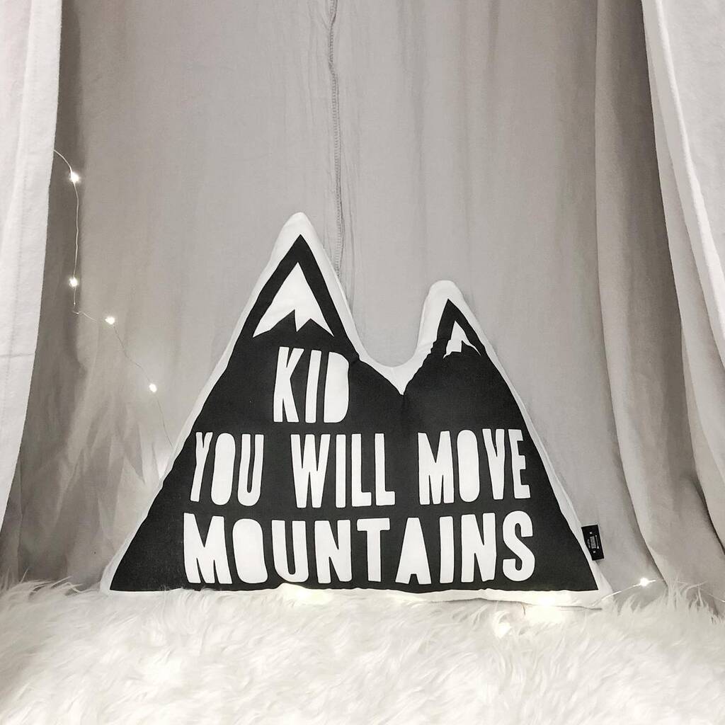 An image of a pillow with the words "kid you will move mountains" printed on it.