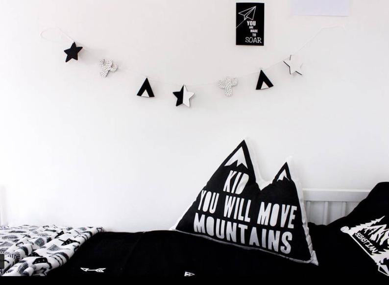 A pillow with an encouraging quote that reads "kid you will move mountains"