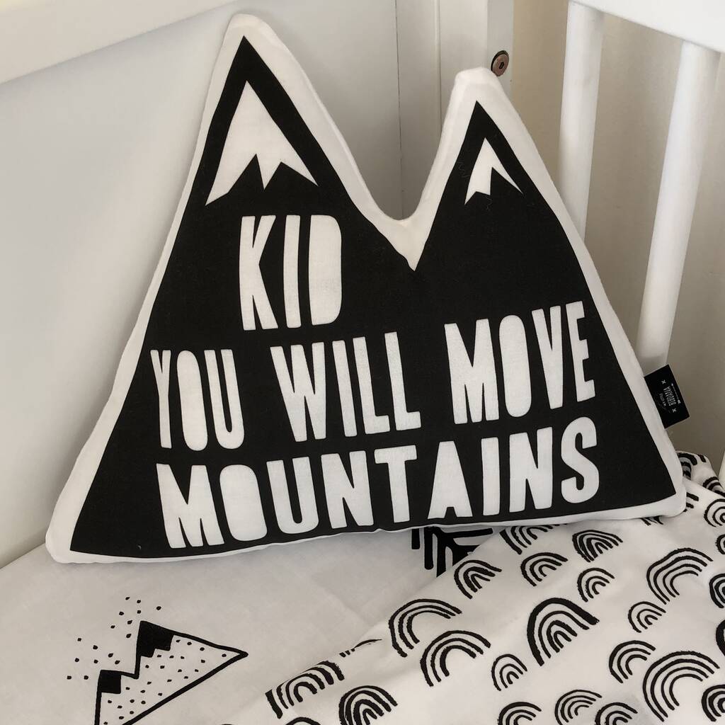 A cozy pillow with the inspirational phrase "kid you will move mountains" displayed on it.