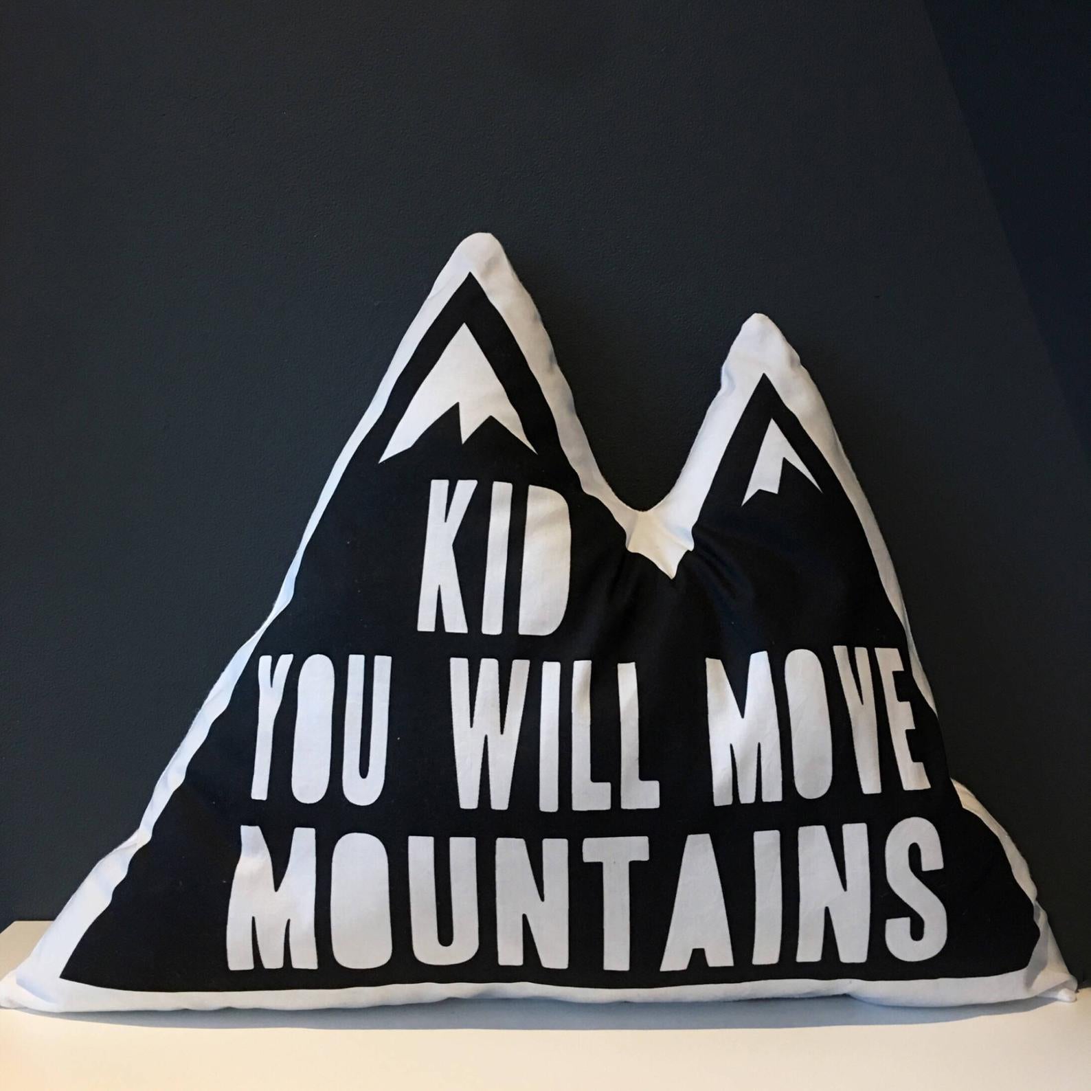 A decorative pillow featuring the inspiring message "kid you will move mountains".