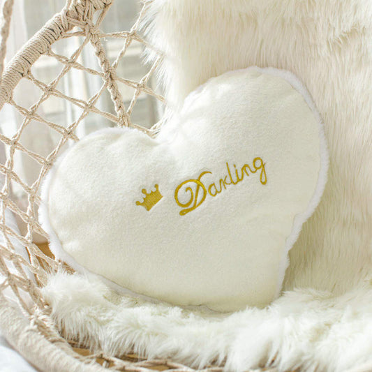  White pillow with the word "darling" in elegant cursive script, adding a touch of charm to any room decor.