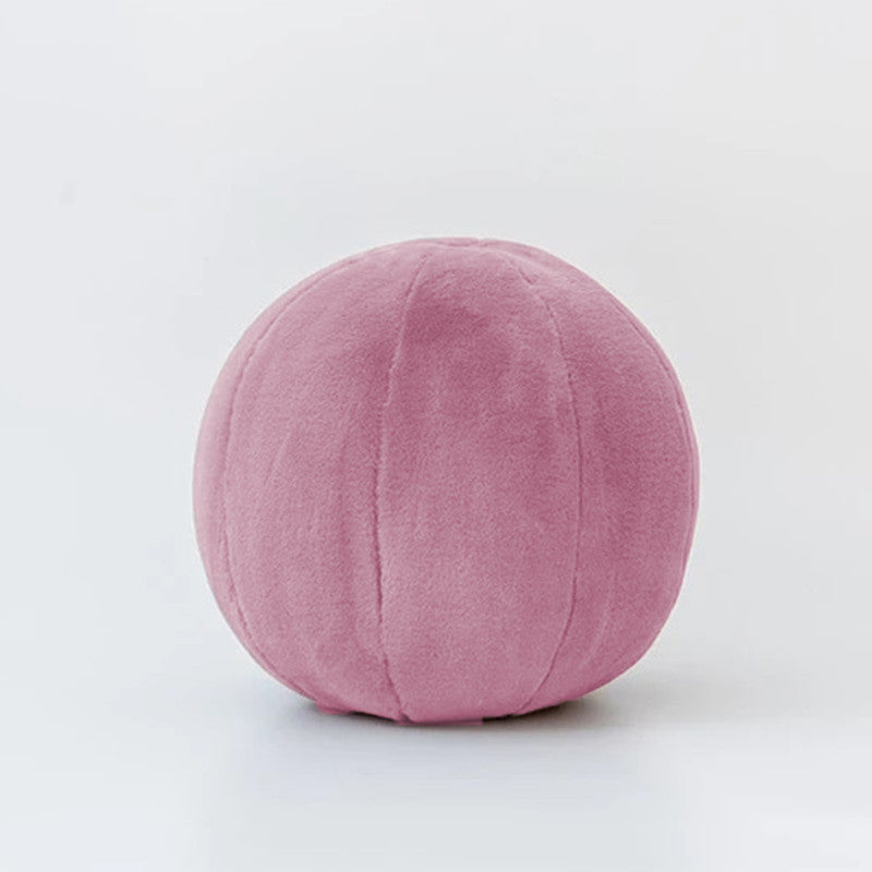 A cozy pink ball pillow on a clean white background, perfect for adding a touch of softness to any space.