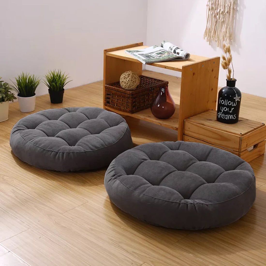 Two round floor pillows on a wooden floor.