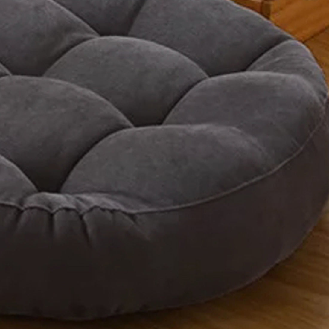 Two round pillows on a hardwood floor, adding a touch of comfort to the room's decor.