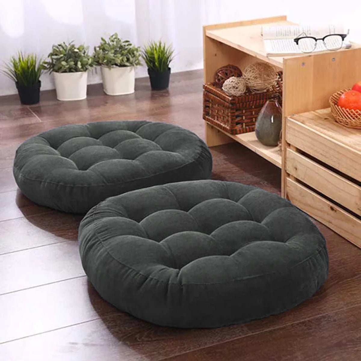 Two circular floor pillows on a wooden surface.