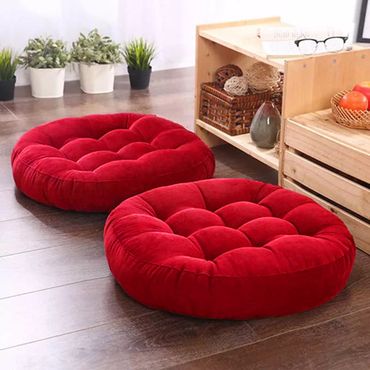 Two red cushions placed on a wooden surface.