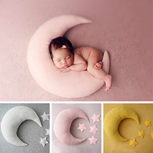 A peaceful baby girl sleeping on a crescent-shaped pillow adorned with stars.