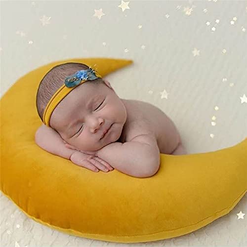 2. Image of a sleeping newborn on a yellow pillow with a crescent shape.