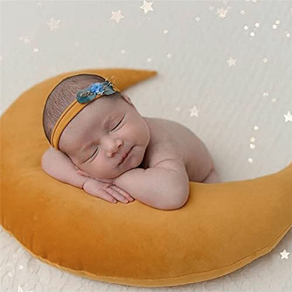 2. An adorable baby napping on a pillow in the form of a crescent moon.