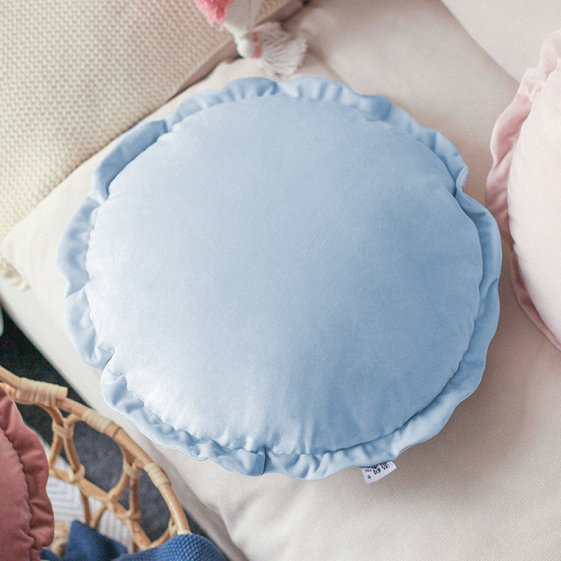 A round pillow adorned with blue and pink ruffles, adding a touch of elegance and charm to any space.