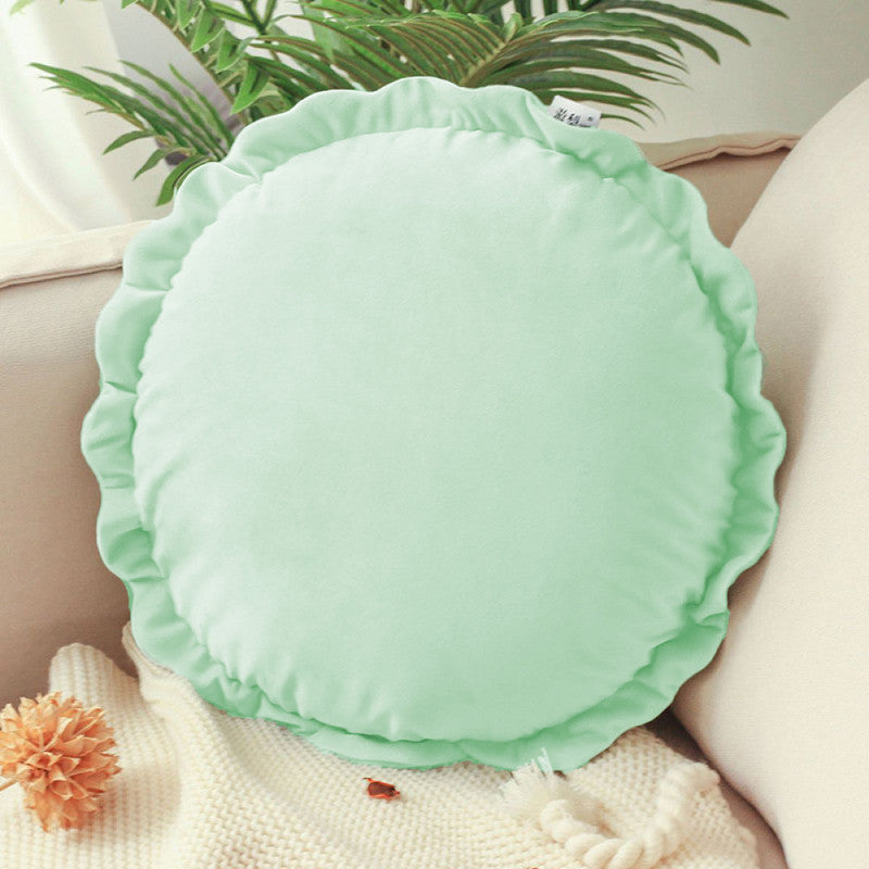 Colorful round pillows on a bed.