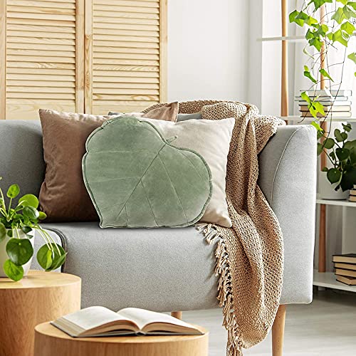 Comfy sofa adorned with leaf and many cushions.
