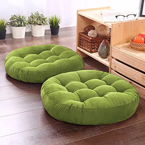Two round green pillows on wooden surface.