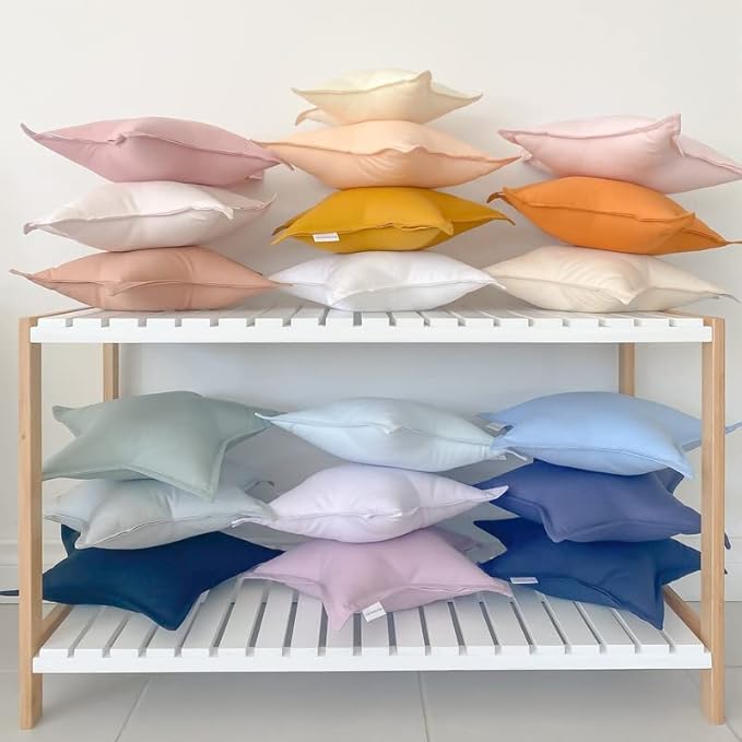  Various colored pillows on a shelf.