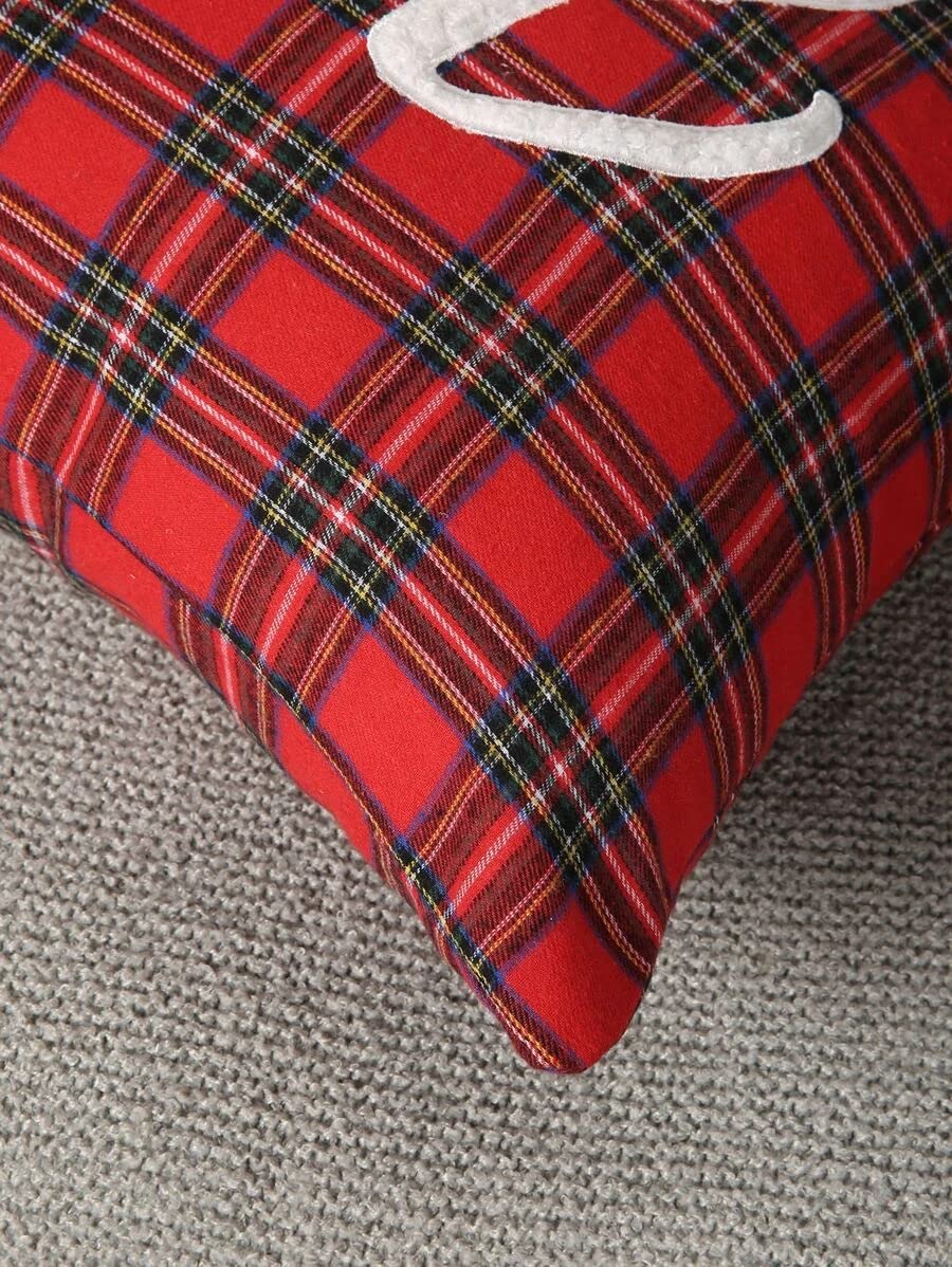 Plaid pillow in red and black on chair with plant.