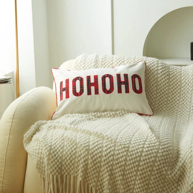 A cozy white couch with a vibrant red and white pillow, perfect for relaxing and adding a pop of color to any room.