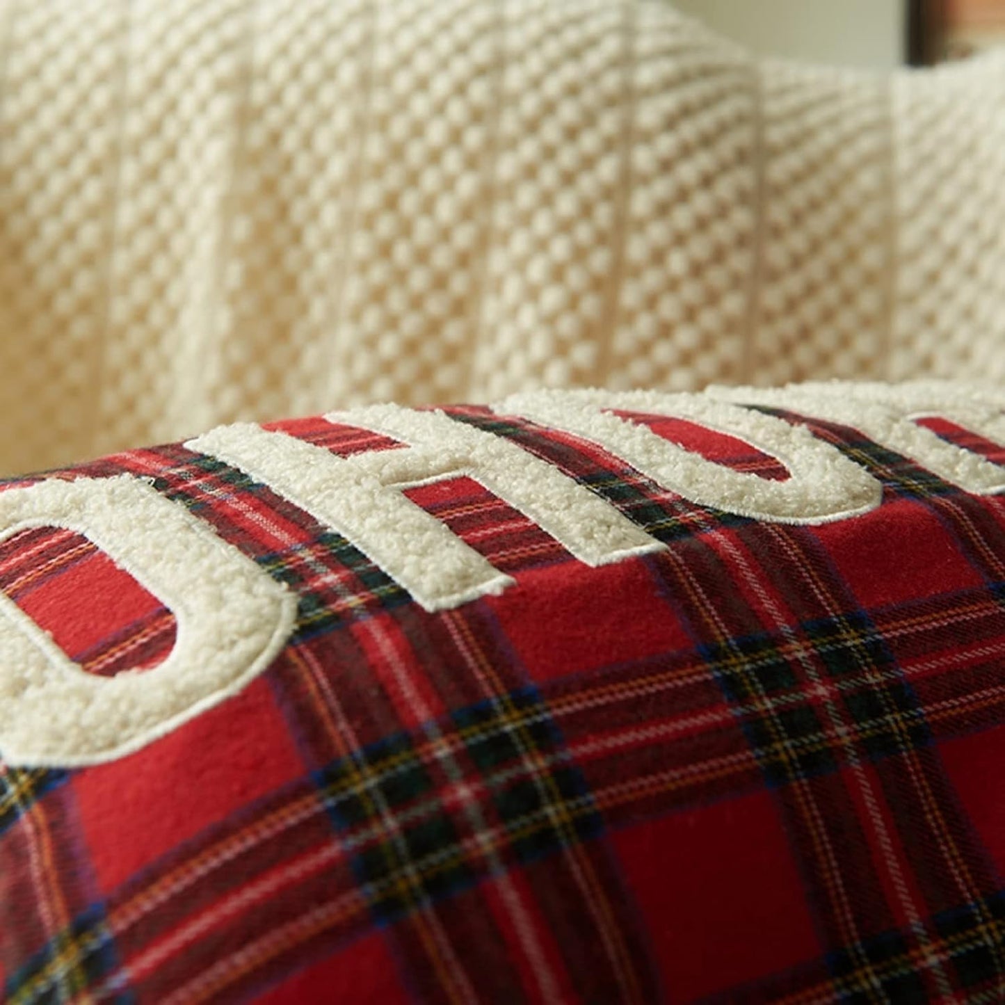 Red pillow adorned with 'ho ho ho' text, a fun addition to your Christmas decor.