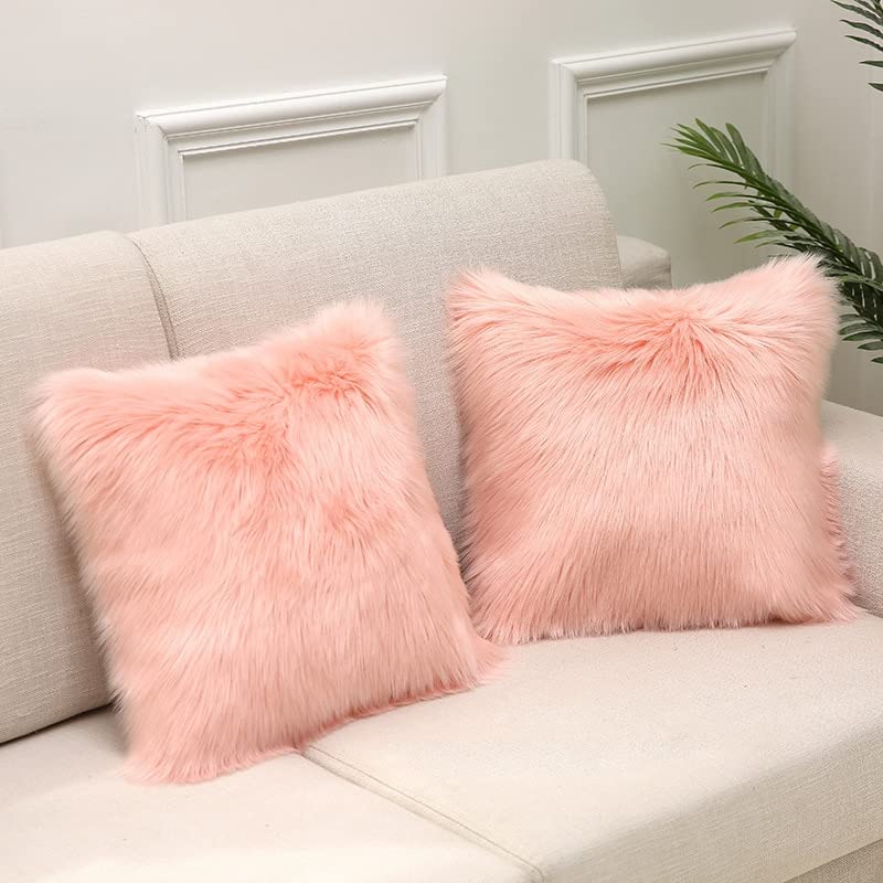 A cozy couch with a pink pillow and a lovely plant. Perfect for relaxing and adding a touch of nature to your living space.